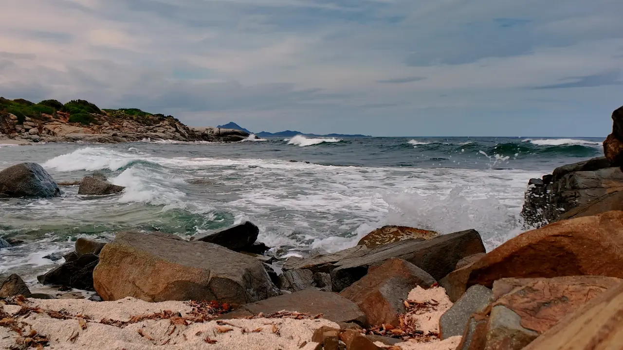 Waves reaching the shore along a rocky coastline